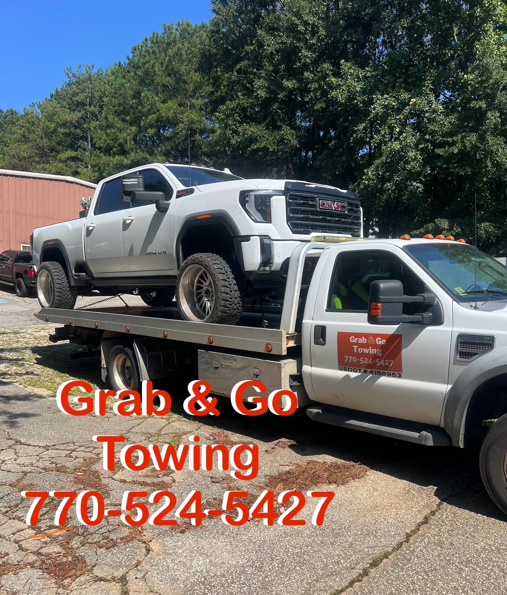 Grab & Go Towing flatbed truck transporting a pickup